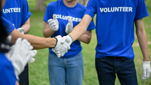 Close-up image of a male volunteer shakes hands with his team after finishing volunteer work - Powered by Adobe
