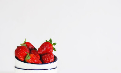 Ripe organic strawberries in a white bowl
