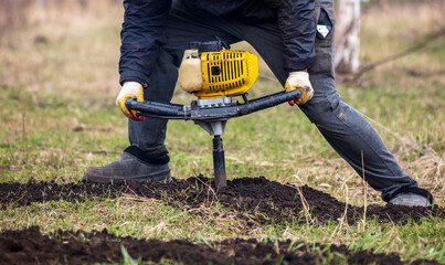 Worker digs the ground with a gasoline blower in the garden
