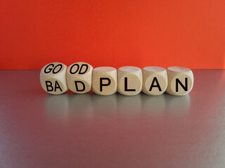 Good a bad plan symbol. Turned wooden cubes and changes words 'bad plan' to 'good plan'. Beautiful grey table, red background, copy space. Business and good plan concept.