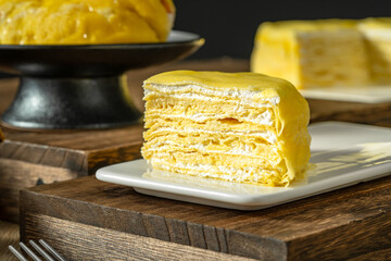 Durian millefeuille, indoor close-up, on a wooden tabletop