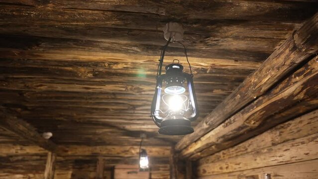 A kerosene lamp burns in a wooden house