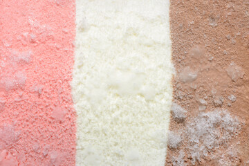 texture of pink, white and chocolate ice cream with ice like background, close up