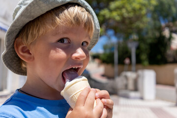 little boy 3 years old eats ice cream and smiles
