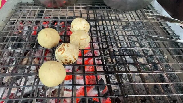 Litti or Litthi chokha being prepared on an iron grill, barbecue in Bihar.