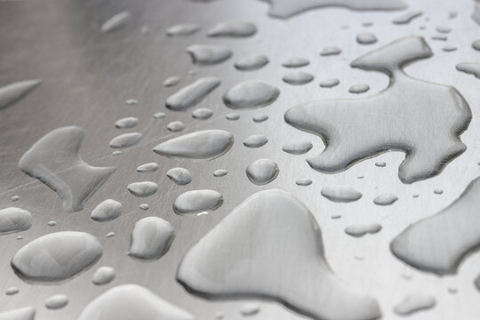 Image of water droplets on a silver steel plate