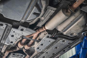 Close-up of resonator in car exhaust system.