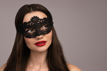 Fototapeta premium Girl in a mask with red lips, on a gray background