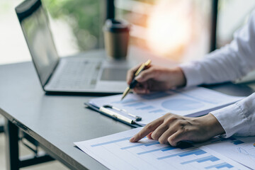 Young Asian female accountant working with financial documents at home with laptop, planning budget, saving money, audit concept close up pictures