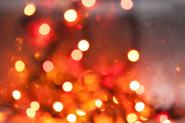 Bokeh background.Defocused fire candles. Bokeh light, twinkling blurry lights on red. Abstract blurred background in red-orange colors.