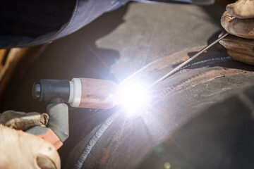 Detail of Blue electric welding arc. Pipe welding. Construction of a new pre-insulated hot water pipeline. Heating network repair. Welder at work. Heat distribution in the city.