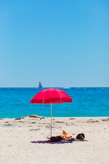 Fototapeta na wymiar Female vacationers suntanning on sandy beach