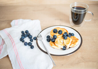 Cheese pancake with blueberries on a table. Syrniky, cottage cheese - a dish of Belarusian, Russian, Ukrainian and Moldovan cuisines in the form of fried cakes made of cottage cheese and flour