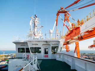 Navigational bridge of ultra large container ship during cargo operations in port with gantry crane