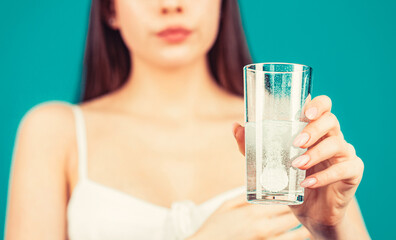 Woman taking a pill with a glass of water. Woman taking drugs to releave headache. Brunette take...