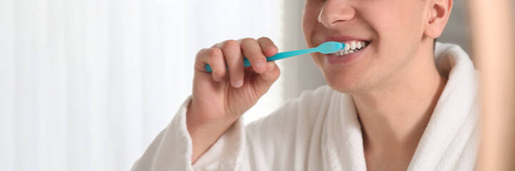 Man brushing his teeth with toothbrush, closeup. Banner design with space for text