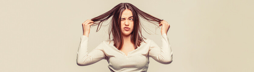 Frustrated woman having a bad hair. Woman having a bad hair, her hair is messy and tangled. Girl having a bad hair. Bad hairs day