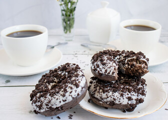 Chocolate donuts with cup of coffee. on white wooden table.