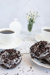 Chocolate donuts with cup of coffee. on white wooden table.