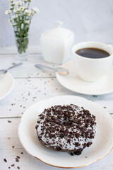 Chocolate donuts with cup of coffee. on white wooden table.