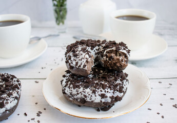 Chocolate donuts with cup of coffee. on white wooden table.