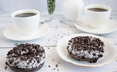 Chocolate donuts with cup of coffee. on white wooden table.