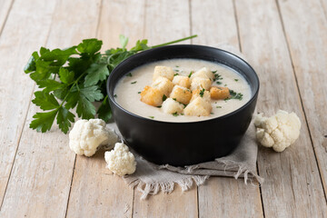 Cauliflower soup in a bowl on wooden table