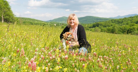 Jeune femme et son chien dans un champ fleuri 