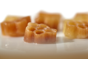 Blurred pasta background. Cooked tan pasta on a white background.