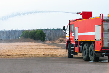 A fire engine pours a jet of water from a nozzle from the roof. Fire alarm at the edge of an...
