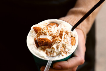 Defocused background .Coffee with cream and almonds. Focus on almonds.