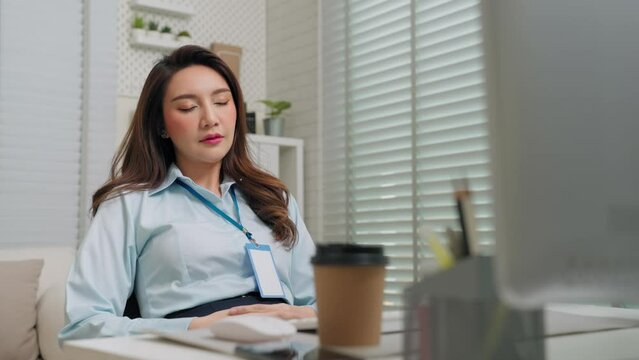 Asian business woman napping and so sleepy while sitting at table in office room. Business person and workplace concept