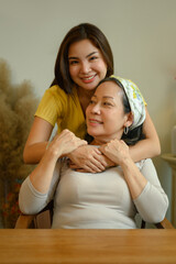 Loving grown up daughter embracing mother from the back, showing each other affection. People and family concept