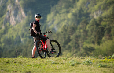 Female cycling on her mountain bike through the countryside on a sunny day.