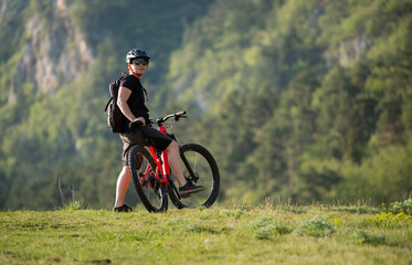 Obraz premium Female cycling on her mountain bike through the countryside on a sunny day.