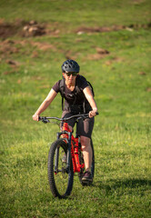 Female cycling on her mountain bike through the countryside on a sunny day.