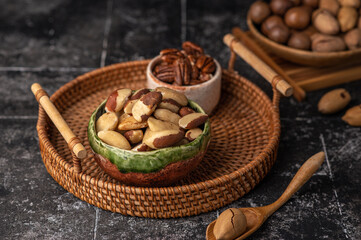 Various Nuts in wooden bowl on dark background.