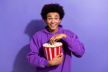 Portrait of cheerful nice person toothy smile eat popcorn enjoy new movie premiere isolated on...