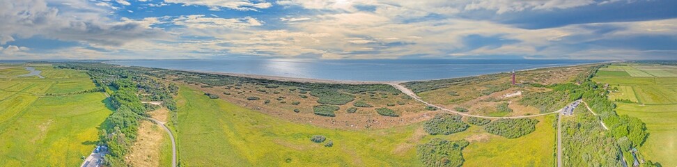 Drone panorama of Ouddorp lighthouse in Holland with surrounding dunes during daytime