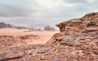 Red orange Mars like landscape in Jordan Wadi Rum desert, mountains background, overcast morning. This location was used as set for many science fiction movies