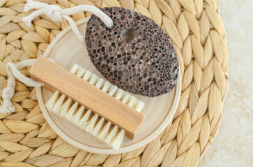Black volcanic pumice stone and massage foot brush with natural bristles. Homemade spa and pedicure concept.