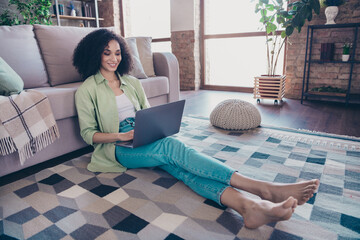 Full body photo of careless girl working freelance laptop copywriter while covid pandemic indoors cozy apartment sofa sit carpet indoors