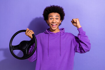 Photo of ecstatic overjoyed guy afro hairdo dressed purple pullover hold steering wheel win new car...