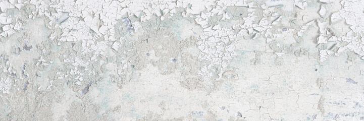 Peeling paint on the wall. Old concrete wall with cracked flaking paint. Weathered rough painted surface with patterns of cracks and peeling. Grunge texture for background and design. High resolution.