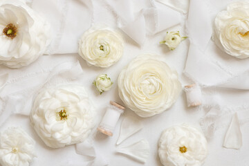 Fototapeta na wymiar Cream roses and white silk ribbons top view, romantic pastel flatlay