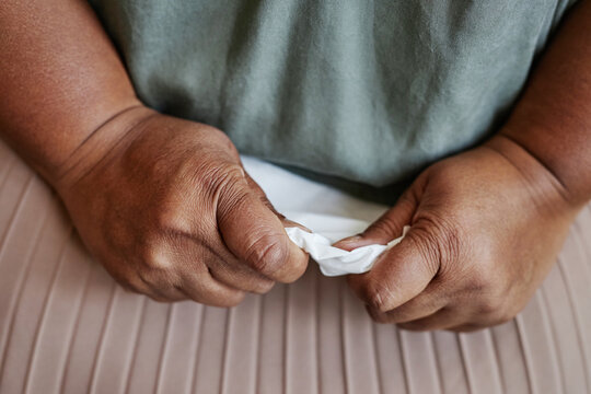 Closeup of black senior woman holding tissue and crying for mental health troubles