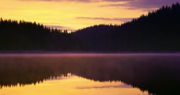 Mystical sunrise over lake water and green forest pine trees. Nature panorama landscape with dam Shiroka polyana (Wide meadow) Rodopi mountain. Bulgaria