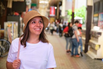 Female tourist visiting indoor japanese market at Dotonbori in Osaka, Japan.