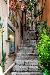 Fotobehang Smal steegje A characteristic narrow alley of Taormina, Sicily, Italy