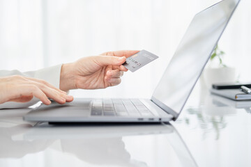 Hands holding credit card and using laptop. Online shopping